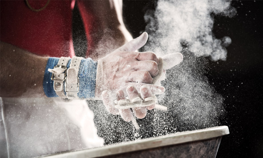 Adult gymnast putting chalk on hands